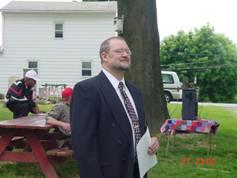 Man in a suit holding an event program.