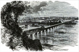 Lithographed image of two bridges as viewed from a bluff. The bridges span a wide river and enter a large town, seen in the distance. One bridge is covered and in two distinct pans divided by an island. The nearer bridge is an uncovered railroad  bridge, with an 1860s steam locomotive pulling three freight or passenger cars, steaming toward the town.